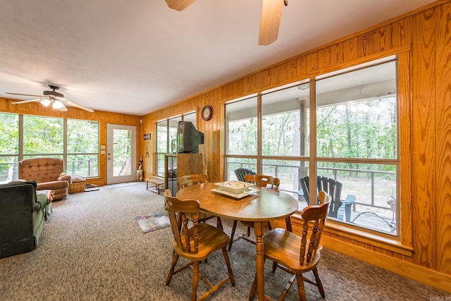 143 Hurricane Dr, Greers Ferry, AR 72067 - dining area with wood walls, a ceiling fan, and carpet flooring