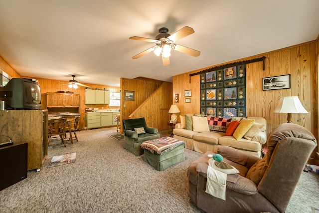143 Hurricane Dr, Greers Ferry, AR 72067 - carpeted living area featuring ceiling fan, wood walls, and stairway