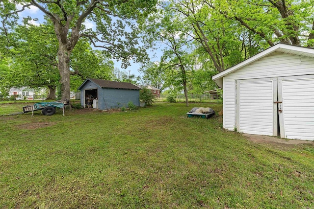 view of yard featuring a storage shed, fence, and an outdoor structure