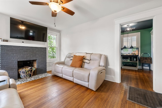 living room with ceiling fan, a fireplace, baseboards, visible vents, and hardwood / wood-style flooring