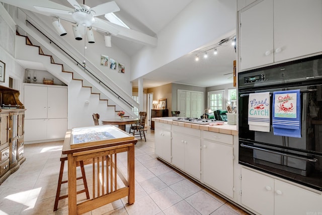 kitchen featuring white gas cooktop, white cabinets, ceiling fan, black oven, and a warming drawer