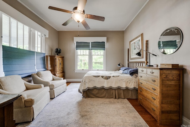 bedroom featuring baseboards, ornamental molding, ceiling fan, and wood finished floors
