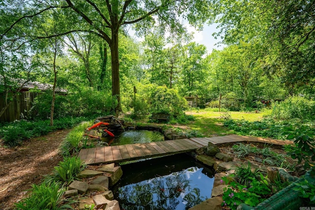 dock area with a garden pond and fence