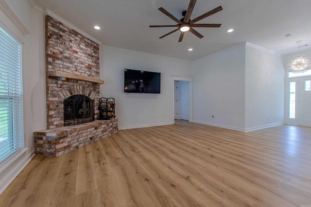 unfurnished living room featuring baseboards, ceiling fan with notable chandelier, wood finished floors, and a fireplace