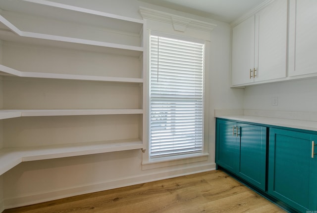 interior space featuring light countertops, green cabinetry, open shelves, and light wood-style flooring