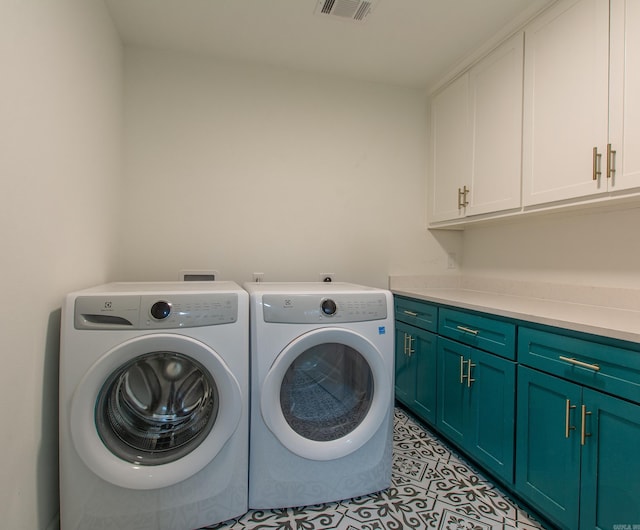 laundry area featuring visible vents, washer and clothes dryer, cabinet space, and light tile patterned flooring