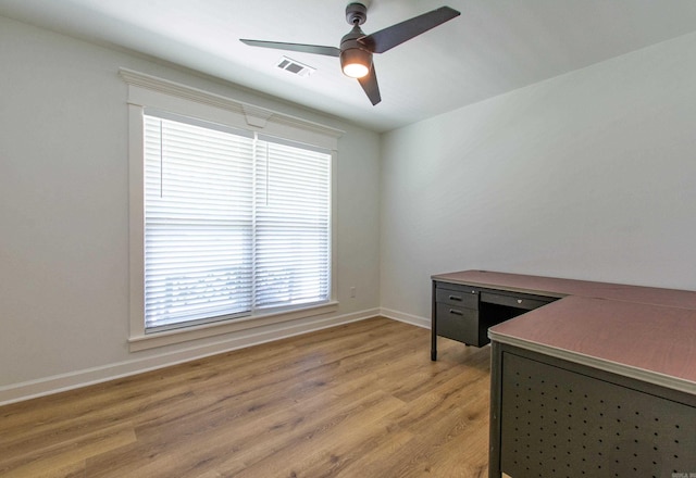 unfurnished office featuring ceiling fan, visible vents, baseboards, and light wood-style floors