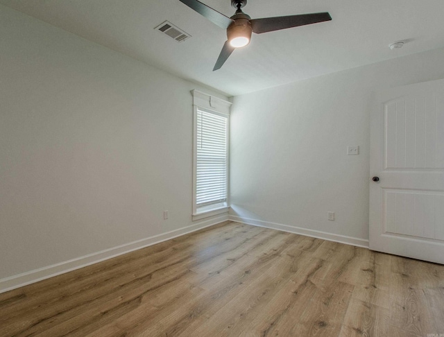 spare room featuring ceiling fan, visible vents, baseboards, and light wood-type flooring