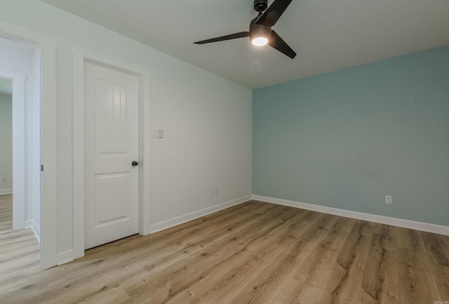 unfurnished room featuring light wood-type flooring, a ceiling fan, and baseboards