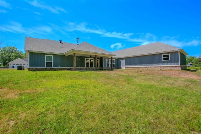 back of house with a yard, ceiling fan, a shingled roof, and central air condition unit