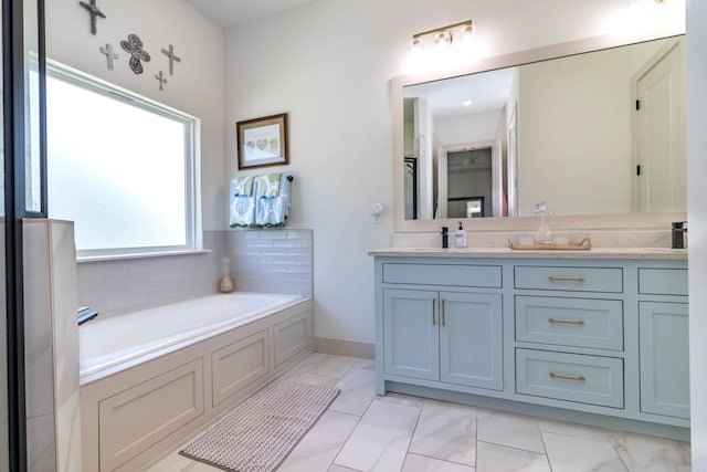 bathroom with a garden tub, double vanity, marble finish floor, baseboards, and a sink