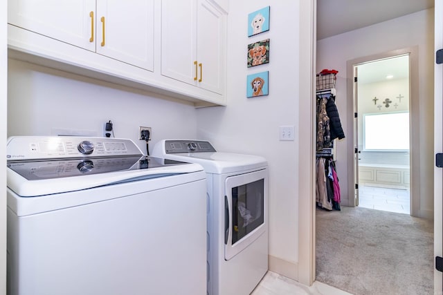washroom with cabinet space, light carpet, and washer and clothes dryer