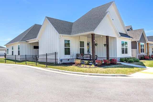 view of front of house with a porch, board and batten siding, roof with shingles, and fence