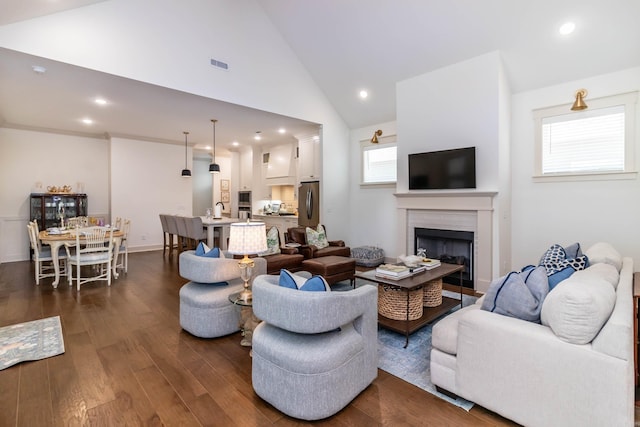 living room with recessed lighting, dark wood finished floors, high vaulted ceiling, and a fireplace