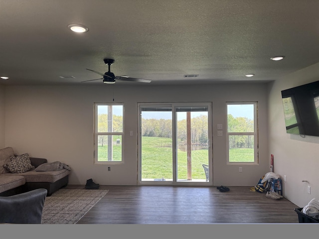 unfurnished living room featuring a ceiling fan, a textured ceiling, visible vents, wood finished floors, and recessed lighting