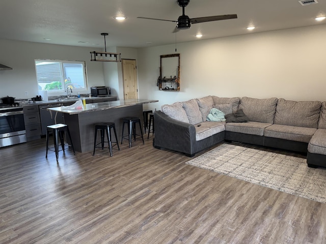 living area with recessed lighting, ceiling fan, and wood finished floors