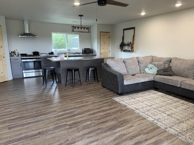 living room featuring ceiling fan, recessed lighting, and dark wood-type flooring