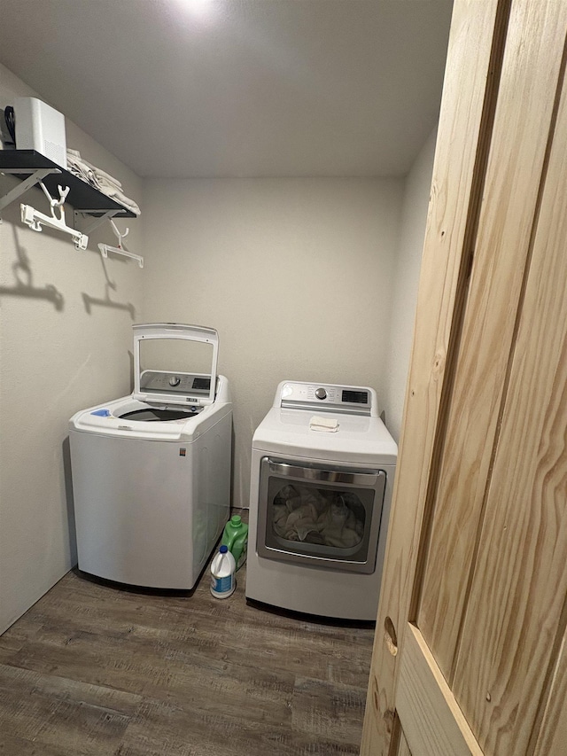 laundry area featuring washer and dryer, laundry area, and dark wood-type flooring