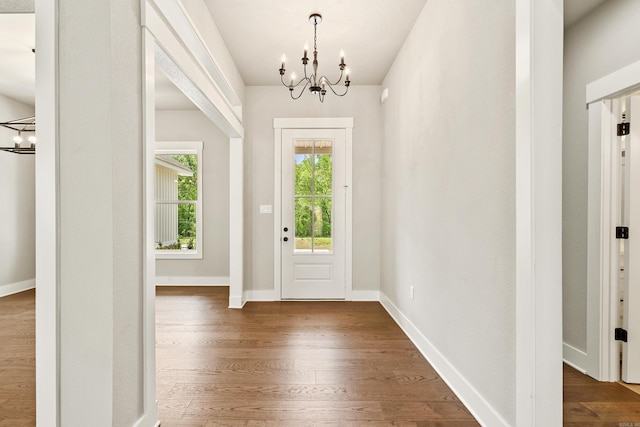 entrance foyer featuring baseboards, a chandelier, and wood finished floors