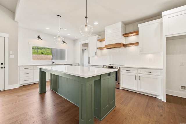 kitchen with open shelves, light countertops, stainless steel electric range, white cabinetry, and green cabinets