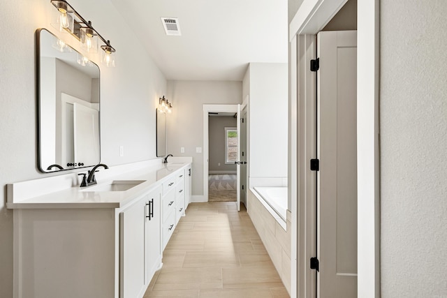 bathroom featuring double vanity, baseboards, visible vents, and a sink
