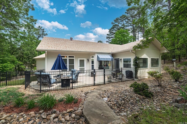 rear view of property with fence, a shingled roof, and a patio area