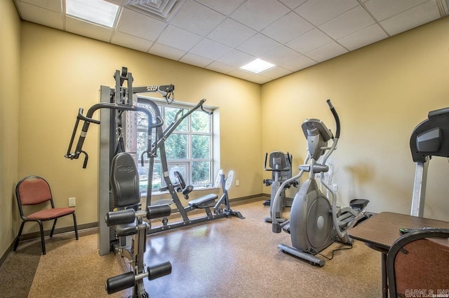 workout room with baseboards and a paneled ceiling