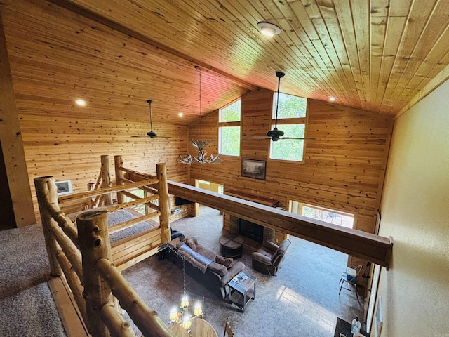 interior space with carpet, lofted ceiling, wooden walls, and wooden ceiling