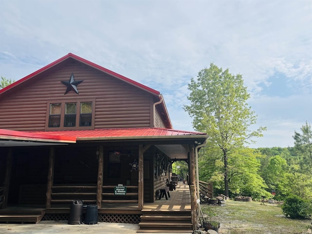 view of front facade featuring a porch and faux log siding