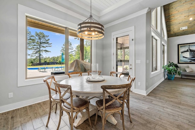 dining room with a notable chandelier, light wood-style floors, baseboards, wooden ceiling, and visible vents