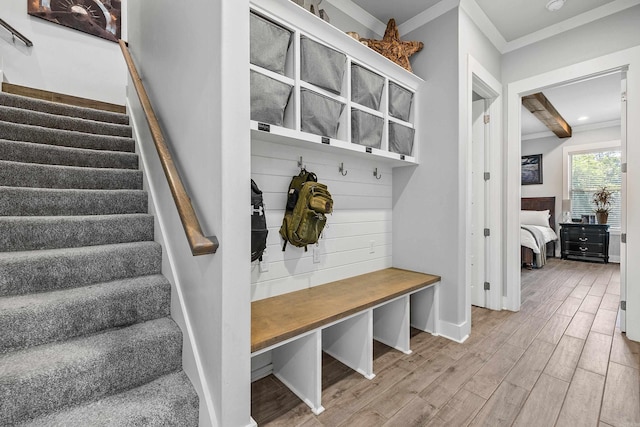 mudroom featuring crown molding, baseboards, and wood finished floors