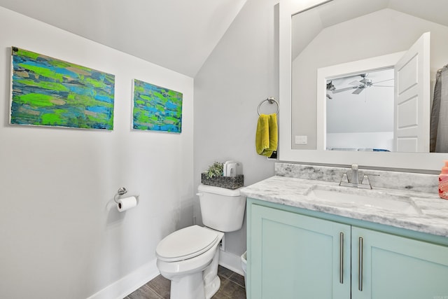 bathroom featuring vanity, toilet, baseboards, ceiling fan, and vaulted ceiling