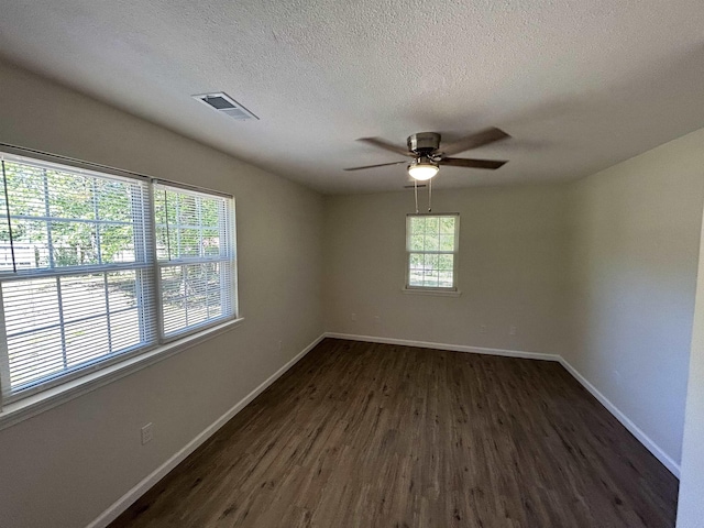 unfurnished room with visible vents, baseboards, ceiling fan, and dark wood-style floors