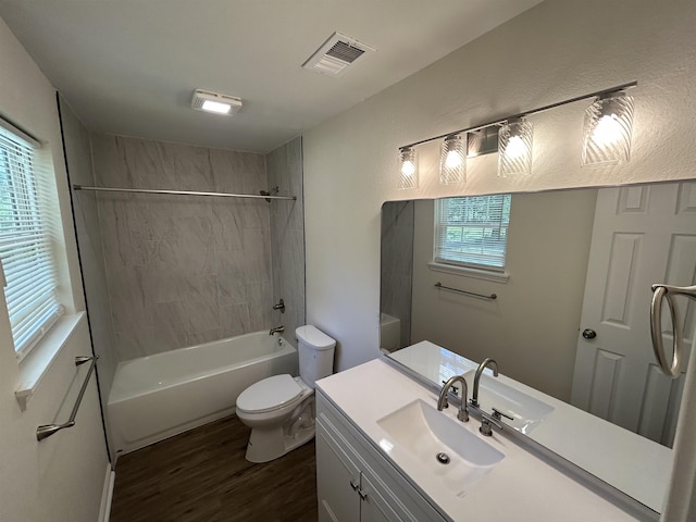 full bathroom featuring washtub / shower combination, vanity, toilet, wood finished floors, and visible vents