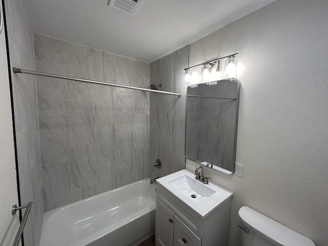 full bath featuring visible vents, vanity, toilet, shower / bathtub combination, and a textured wall