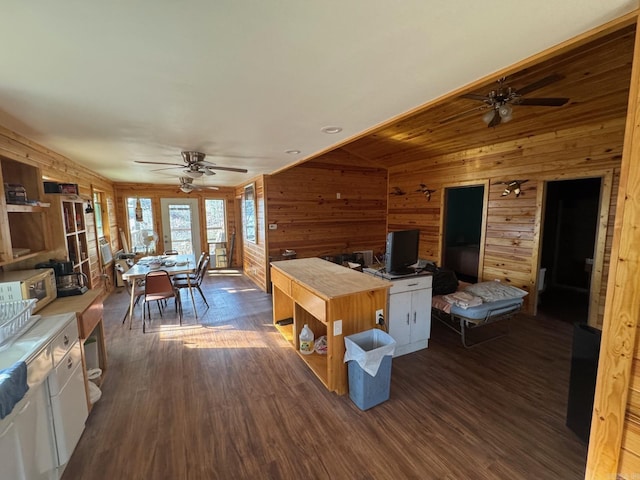 playroom featuring a ceiling fan, dark wood finished floors, and wooden walls