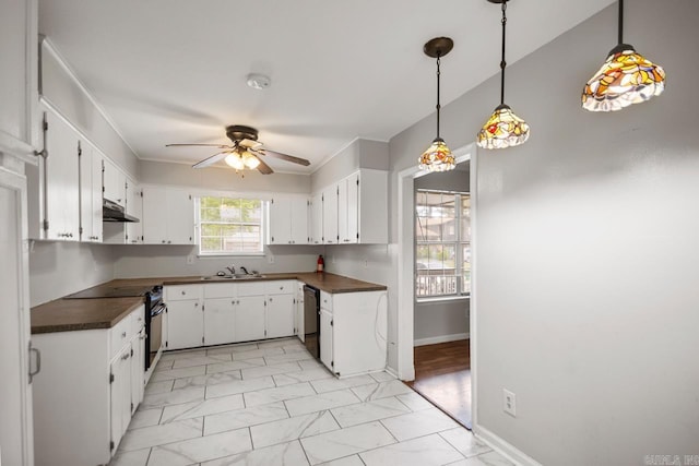 kitchen featuring ceiling fan, dark countertops, a sink, marble finish floor, and under cabinet range hood