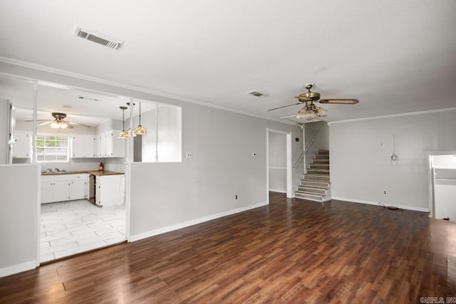 unfurnished living room with visible vents, ornamental molding, baseboards, and ceiling fan