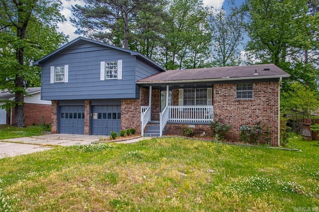 tri-level home featuring a garage, covered porch, a front yard, brick siding, and concrete driveway