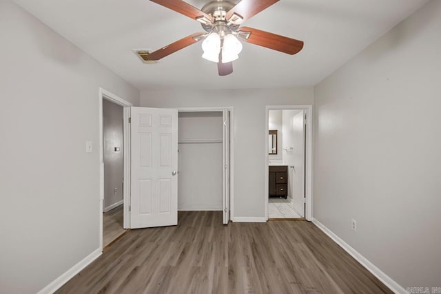 unfurnished bedroom with baseboards, ceiling fan, a closet, and wood finished floors