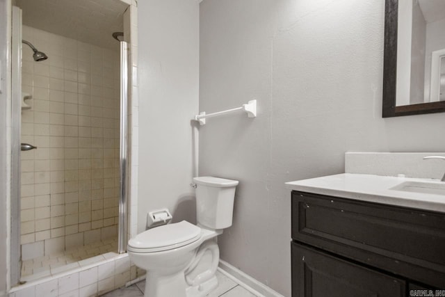 bathroom with vanity, baseboards, a shower stall, and toilet