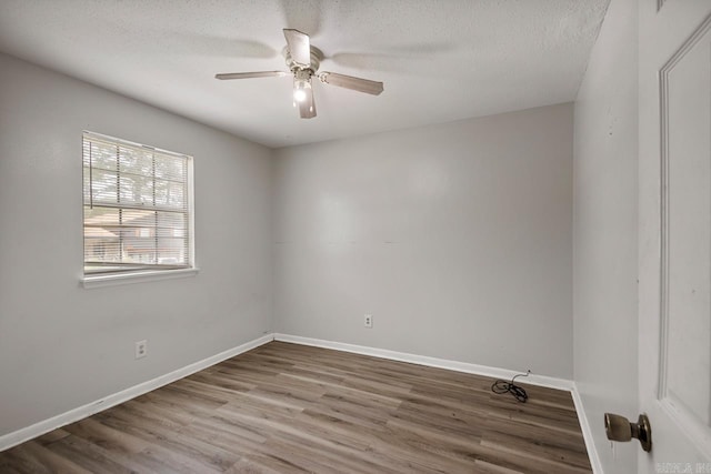 empty room featuring baseboards, a textured ceiling, ceiling fan, and wood finished floors