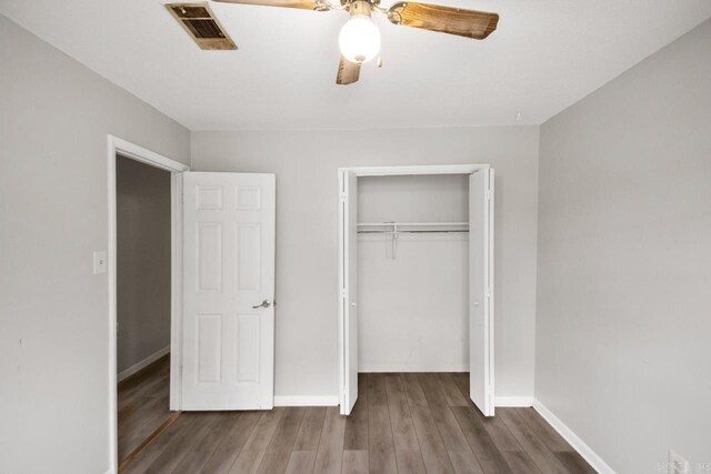 unfurnished bedroom with visible vents, baseboards, wood finished floors, and a closet