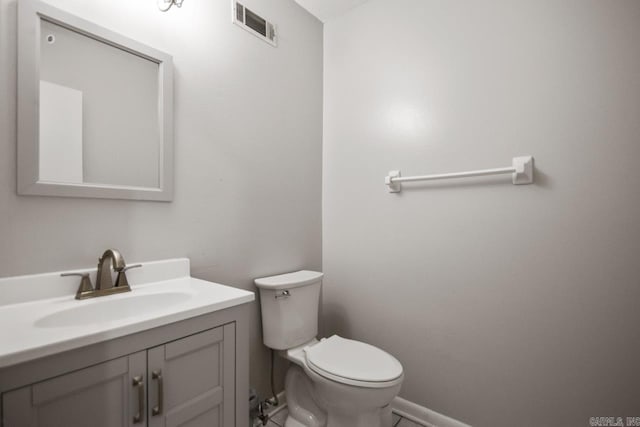 bathroom with visible vents, baseboards, toilet, and vanity