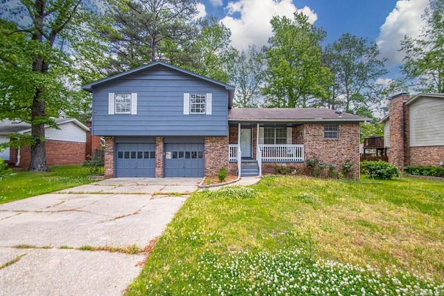 split level home featuring an attached garage, a front lawn, a porch, and driveway