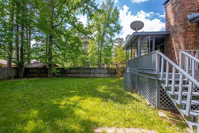 view of yard featuring a fenced backyard, a wooden deck, and stairway
