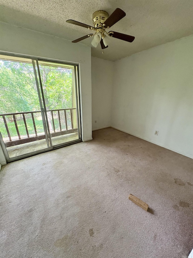 carpeted empty room with a ceiling fan and a textured ceiling