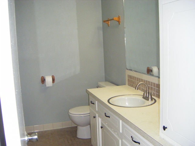 1526 Pine Manor Dr, Arkadelphia, AR 71923 - half bath featuring vanity, baseboards, toilet, and tasteful backsplash