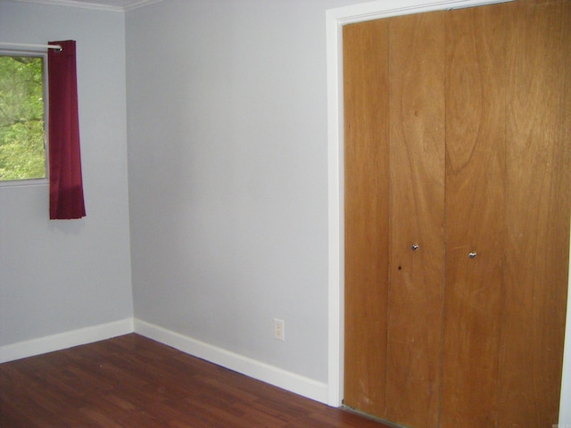 1526 Pine Manor Dr, Arkadelphia, AR 71923 - unfurnished bedroom featuring baseboards, ornamental molding, dark wood-type flooring, and a closet