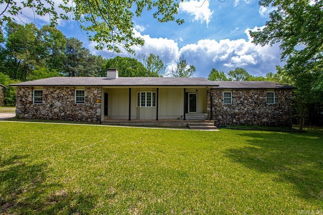 ranch-style house featuring a chimney, board and batten siding, a front yard, and stone siding